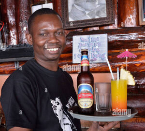 garcon avec de la biere et du kilimandjaro un cocktail en face d une photo de freddy mercury le chanteur a la fin de la reine qui rock band ddy1p3 1